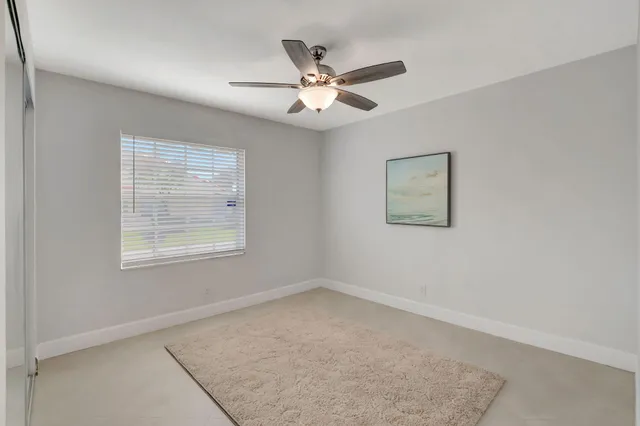 an empty room with a window and a ceiling fan