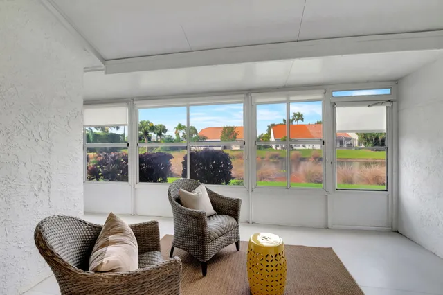 a living room with furniture and a floor to ceiling window