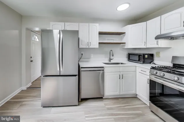 a kitchen with a white stove top oven and cabinets