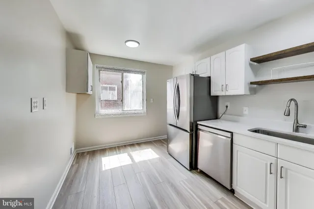 a kitchen with a refrigerator sink and cabinets