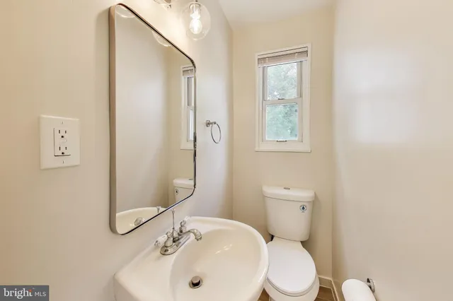 a bathroom with a toilet a sink and mirror
