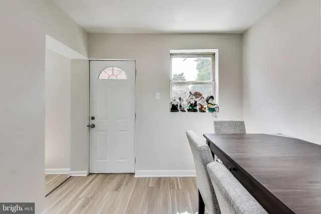 a view of a dining room with wooden floor and a chandelier