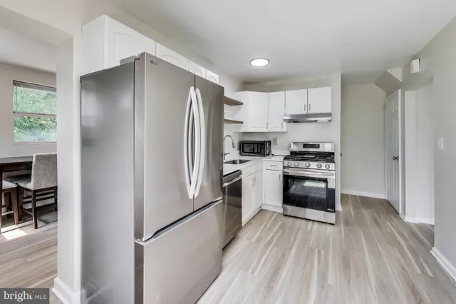 a kitchen with white cabinets and stainless steel appliances