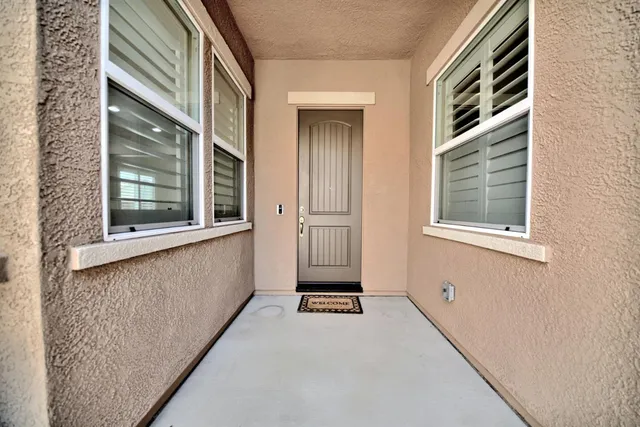 a living room with stainless steel appliances kitchen island granite countertop a rug and white cabinets
