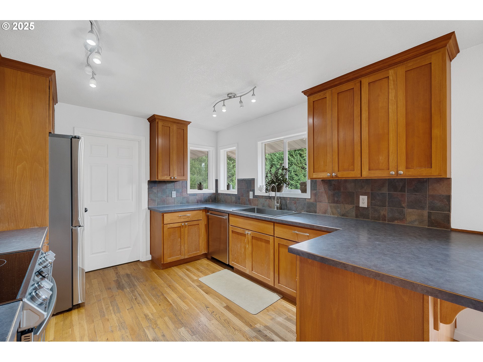 33281 Kammeyer Road Scappoose, OR 97056 - Photo 13 of 48 a kitchen with stainless steel appliances granite countertop a sink dishwasher stove and cabinets with wooden floor