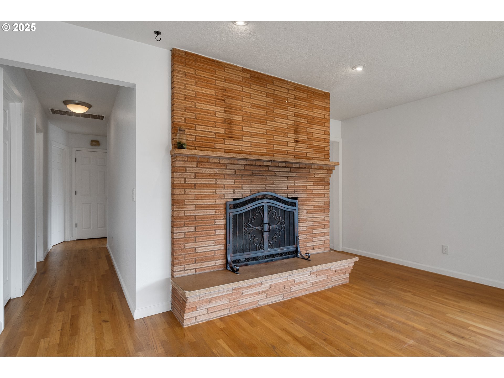 33281 Kammeyer Road Scappoose, OR 97056 - Photo 9 of 48 a view of empty room with wooden floor and fireplace