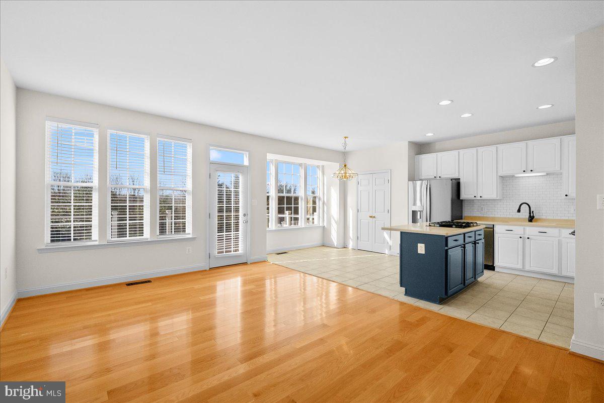 927 Buttonwood Terrace Northeast Leesburg, VA 20176 - Photo 12 of 44 a large kitchen with stainless steel appliances granite countertop a large counter top and a stove top oven