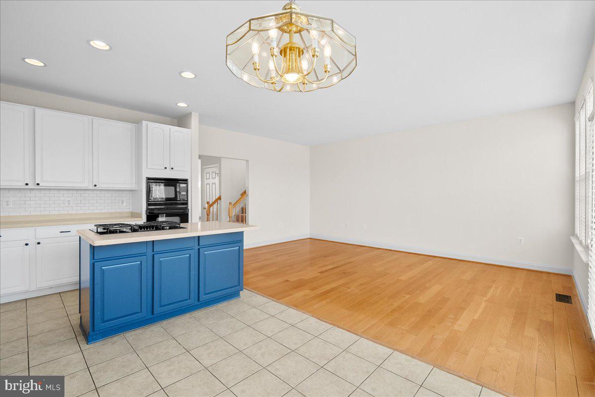 927 Buttonwood Terrace Northeast Leesburg, VA 20176 - Photo 17 of 44 a kitchen with stainless steel appliances granite countertop a stove a sink and a white cabinets