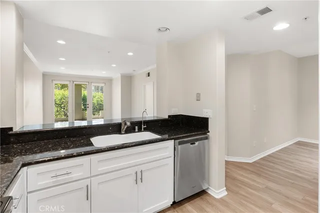 a kitchen with granite countertop white cabinets and sink