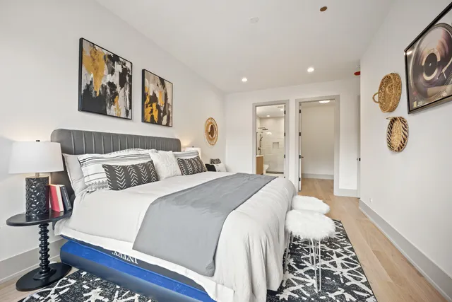 a spacious bedroom with a bed and painting on the wall