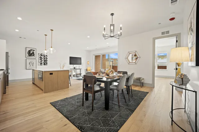a view of a dining room and livingroom with furniture wooden floor a chandelier