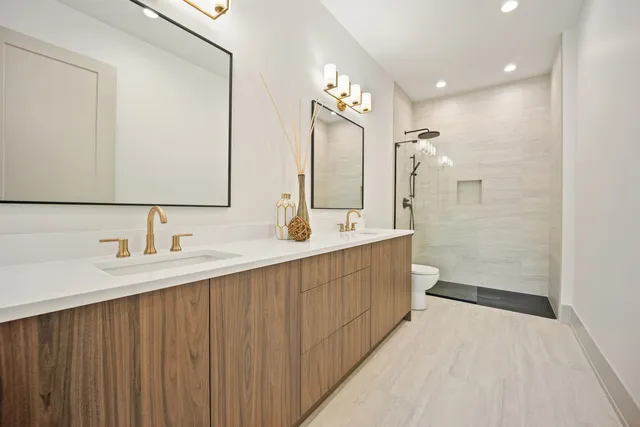 a bathroom with a double vanity sink mirror and shower