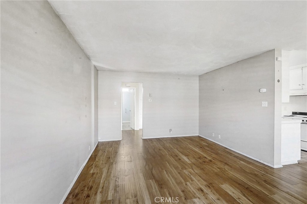 545 Chestnut Avenue, Unit 406 Long Beach, CA 90802 - Photo 3 of 16 a view of an empty room with wooden floor and a window