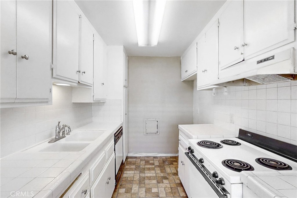 545 Chestnut Avenue, Unit 406 Long Beach, CA 90802 - Photo 6 of 16 a kitchen with a sink a stove and cabinets