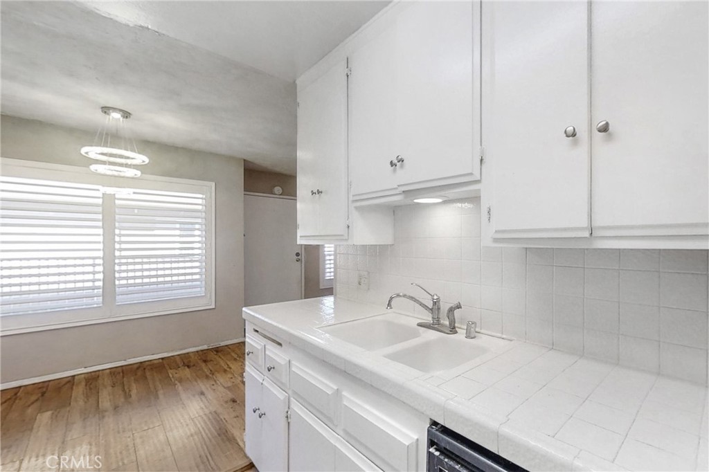 545 Chestnut Avenue, Unit 406 Long Beach, CA 90802 - Photo 7 of 16 a kitchen with granite countertop white cabinets and a sink