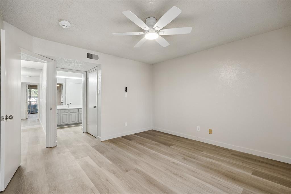 11480 Audelia Road, Unit 136 Dallas, TX 75243 - Photo 14 of 29 Spacious room featuring wood-finish flooring, a ceiling fan with integrated lighting, and a white interior paint scheme