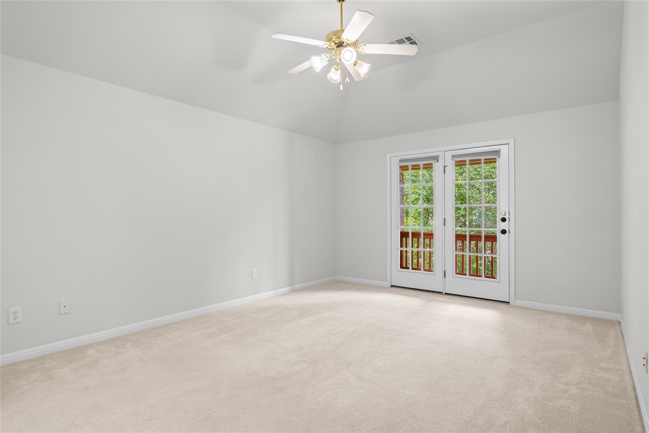 10700 Pointe View Drive Austin, TX 78738 - Photo 20 of 35 A spacious room features a vaulted ceiling, soft carpet, and French doors leading to a private outdoor space.