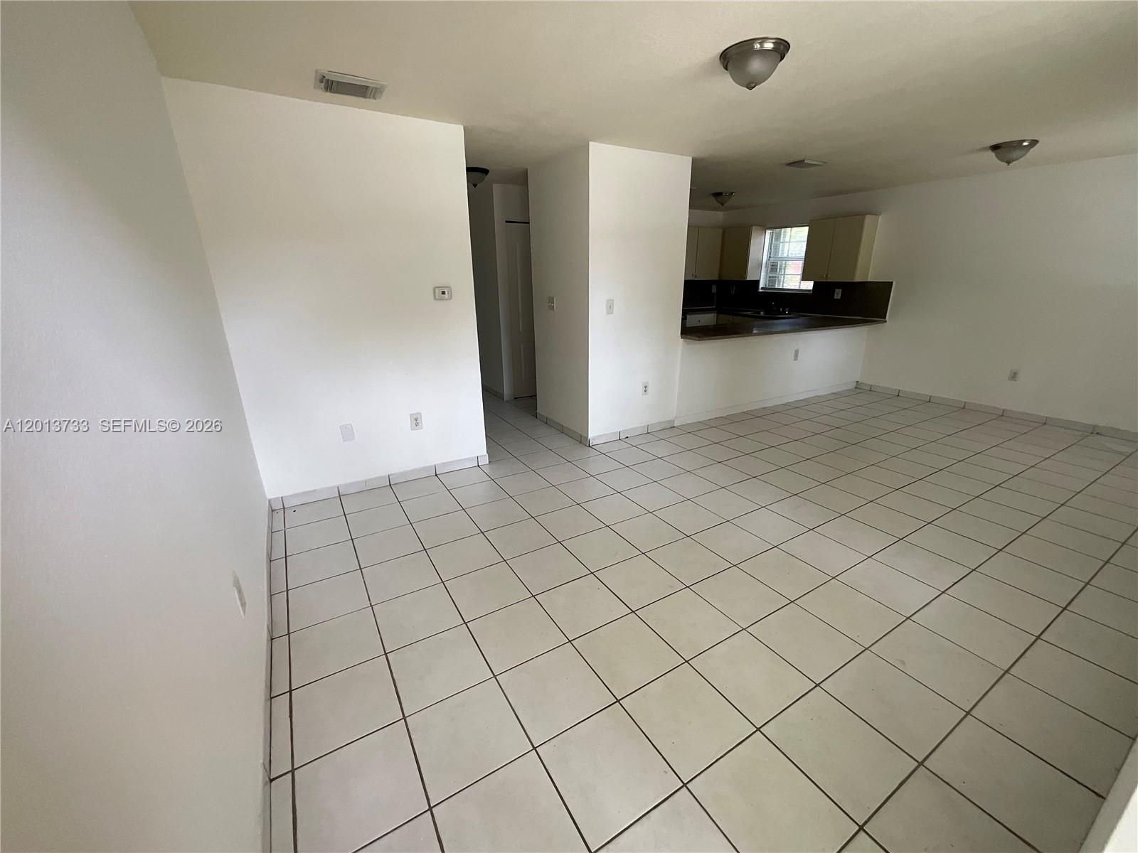 209 Northeast 141st Street, Unit 4 Miami, FL 33161 - Photo 2 of 13 a view of a refrigerator and window in a kitchen