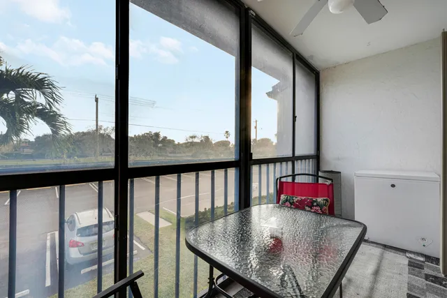 a view of a living room with a floor to ceiling window and wooden floor
