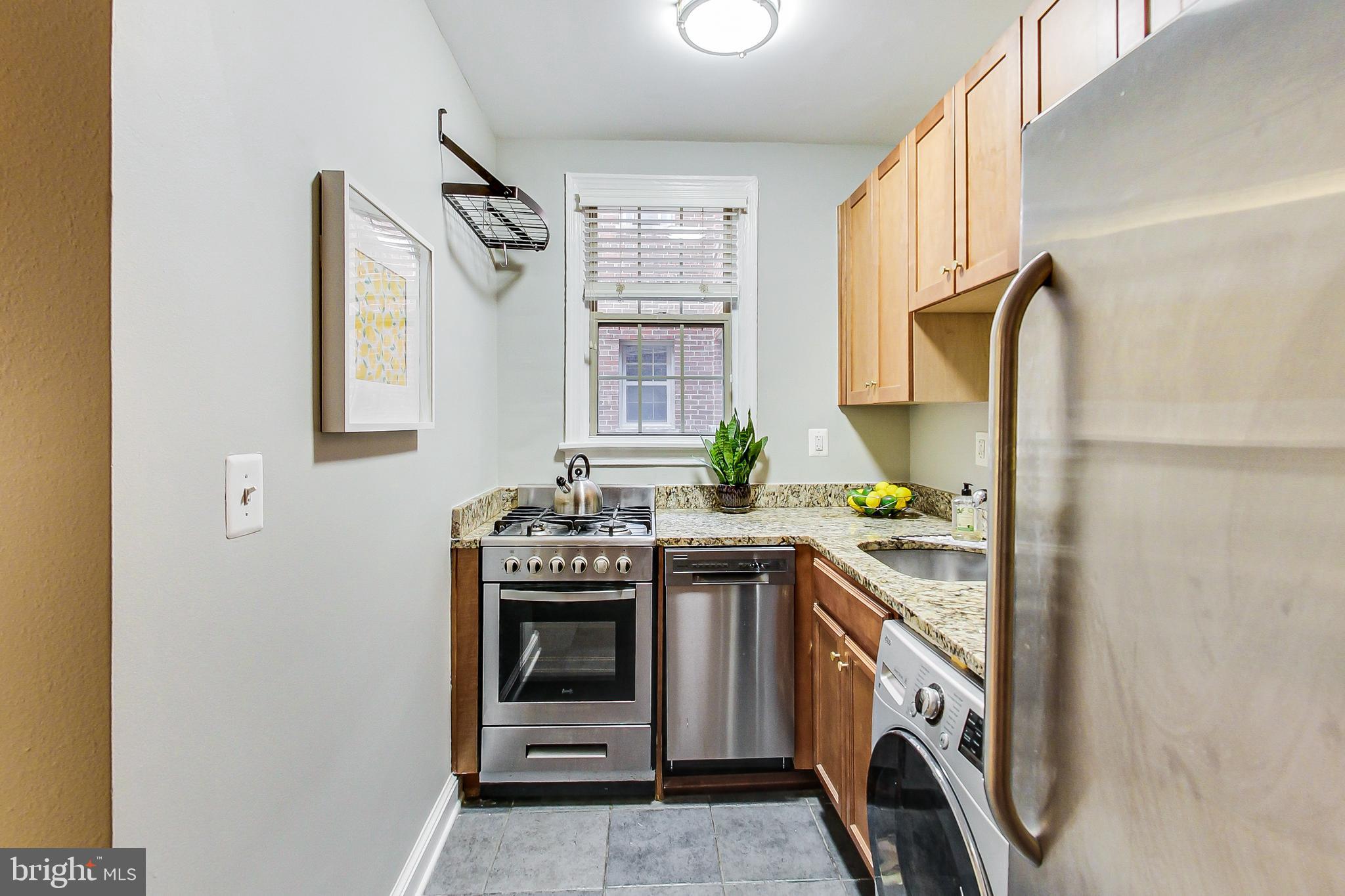 1441 Euclid Street Northwest, Unit 105 Washington, DC 20009 - Photo 9 of 20 a kitchen with a stove top oven sink and window