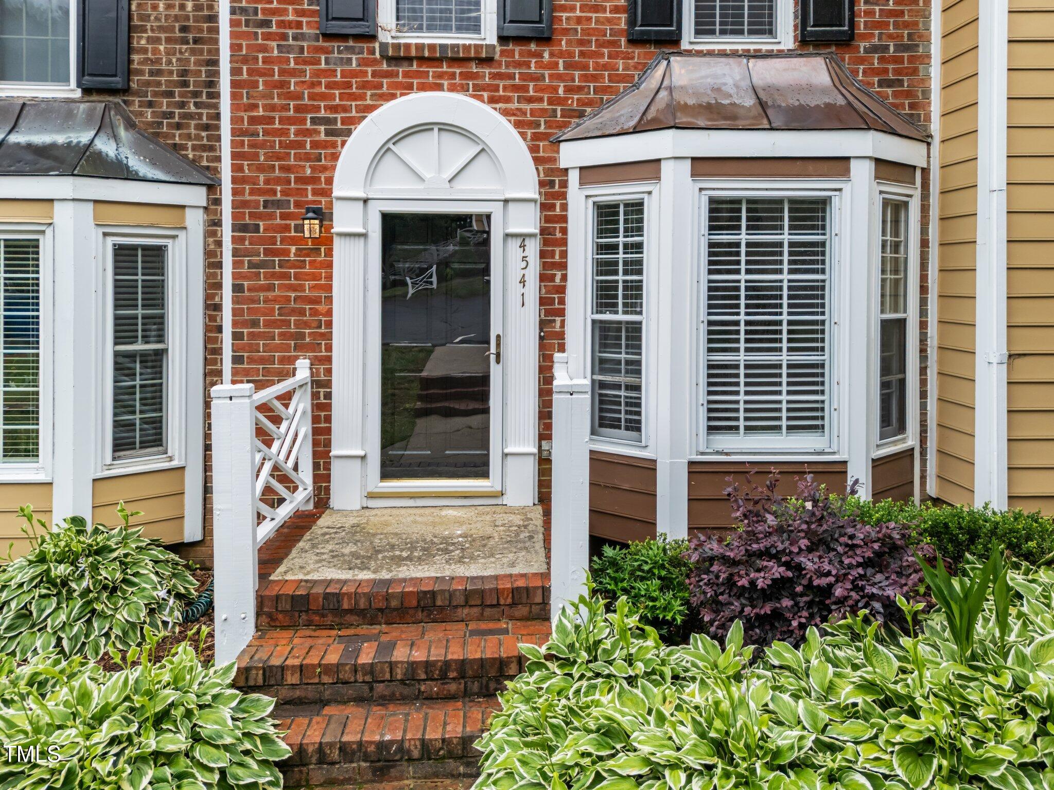 a front view of a house with plants