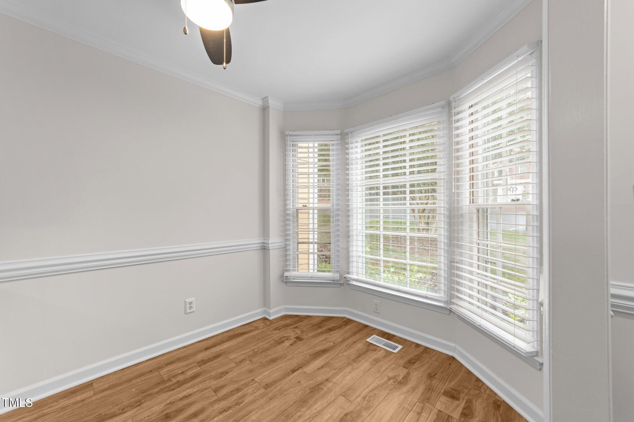 4541 Hershey Court Raleigh, NC 27613 - Photo 4 of 25 a view of an empty room with wooden floor and a window