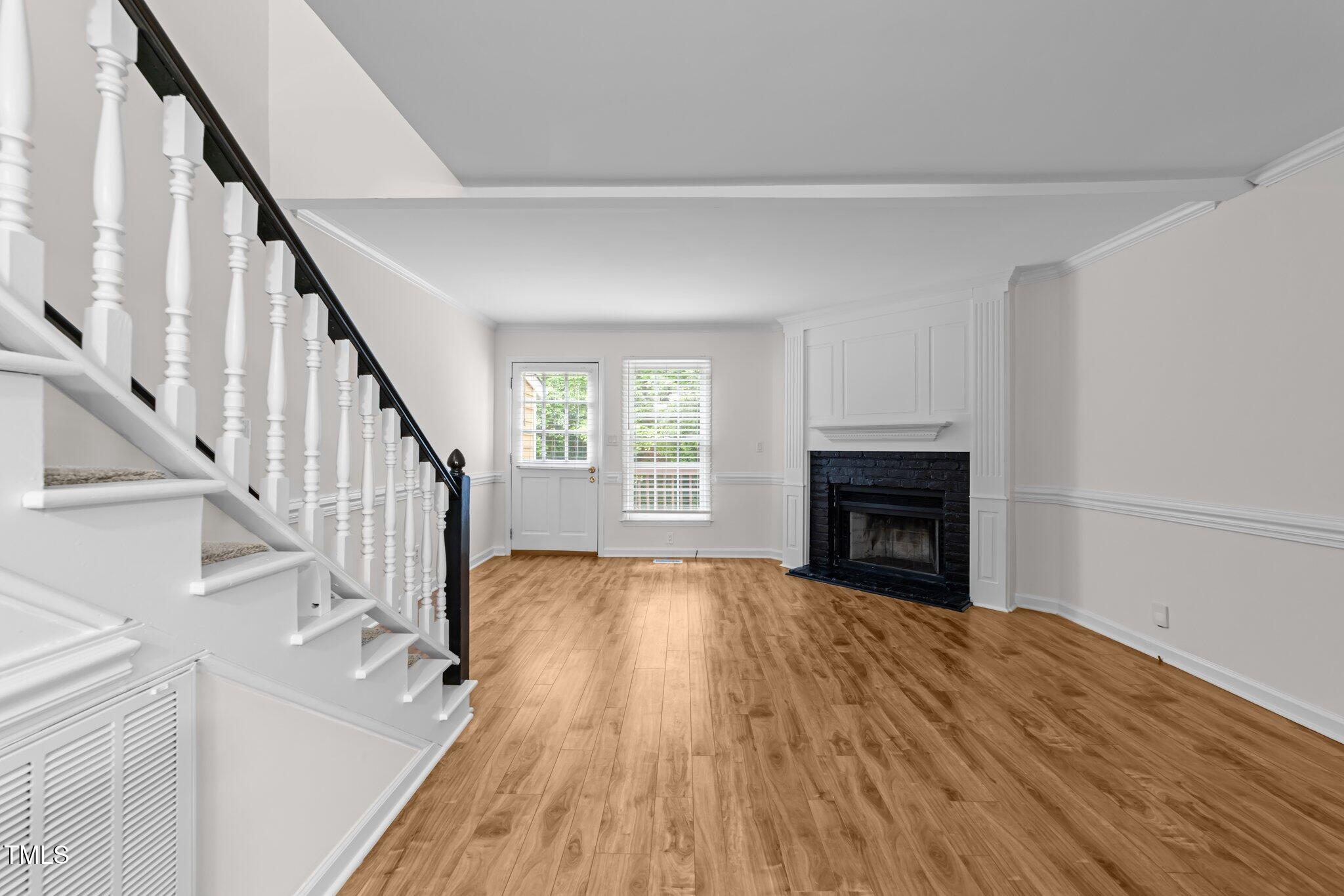 4541 Hershey Court Raleigh, NC 27613 - Photo 8 of 25 a view of empty room with wooden floor and fireplace