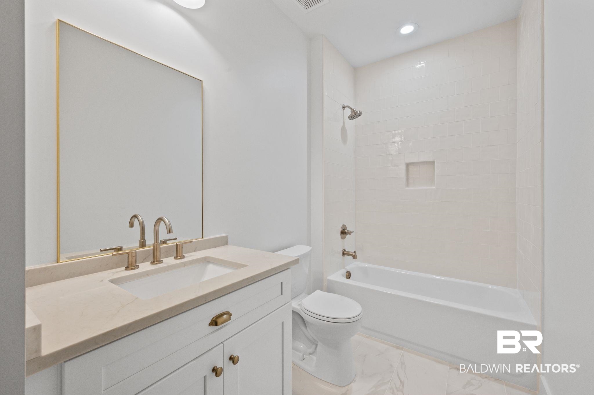 12412 Mannich Lane Foley, AL 36535 - Photo 19 of 23 Full bathroom with tile patterned flooring, vanity, tiled shower / bath combo, and toilet
