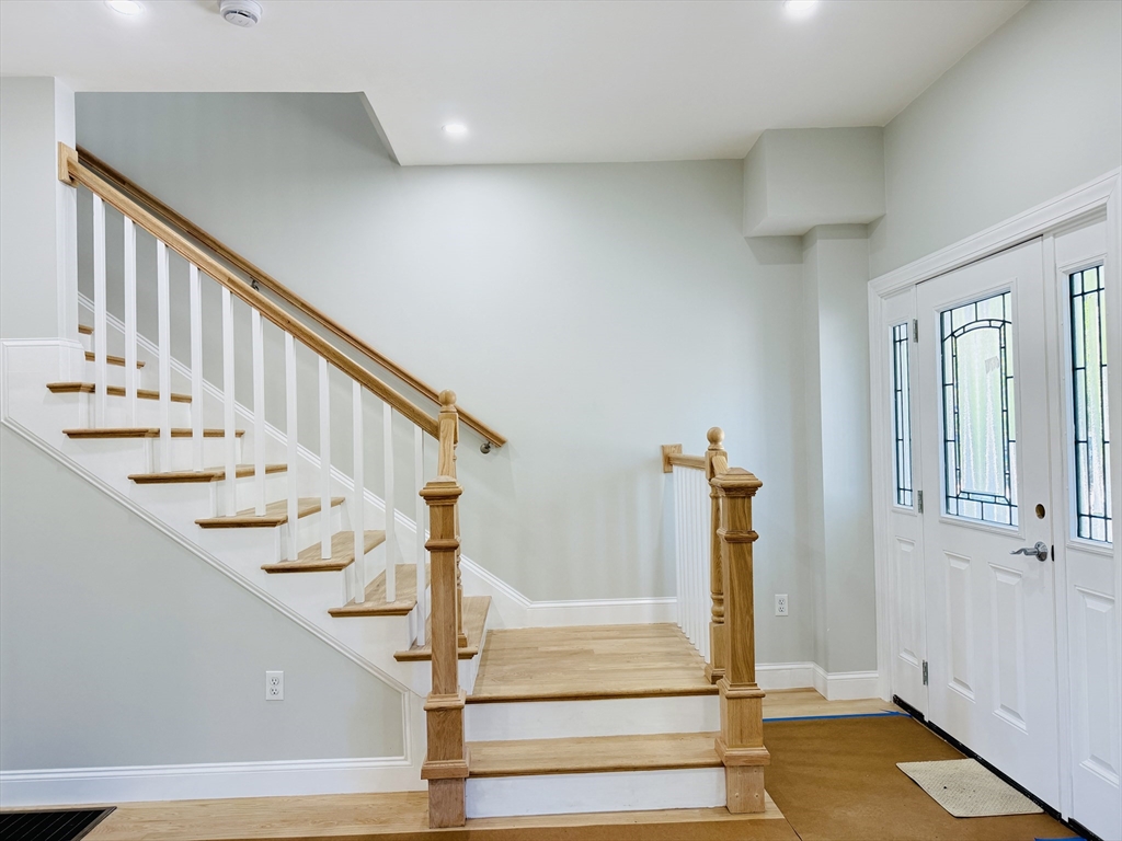 4 Baldwin Street, Unit 4 Newton, MA 02458 - Photo 13 of 30 a view of staircase with lots of frames on wall and wooden floor