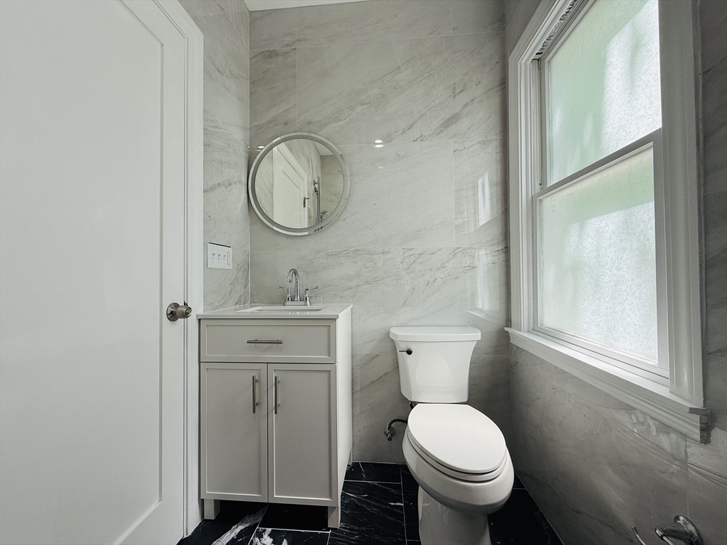 4 Baldwin Street, Unit 4 Newton, MA 02458 - Photo 16 of 30 a bathroom with a toilet a sink and a window