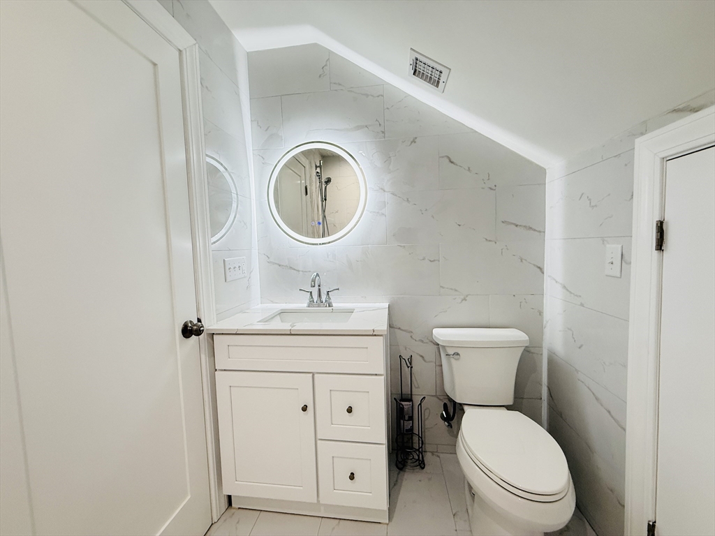 4 Baldwin Street, Unit 4 Newton, MA 02458 - Photo 25 of 30 a bathroom with a toilet a sink and a mirror