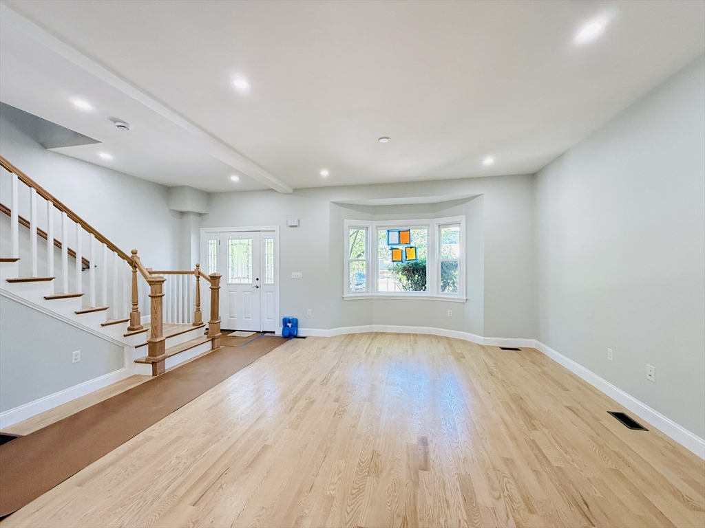 4 Baldwin Street, Unit 4 Newton, MA 02458 - Photo 5 of 30 a view of an empty room with wooden floor and a window