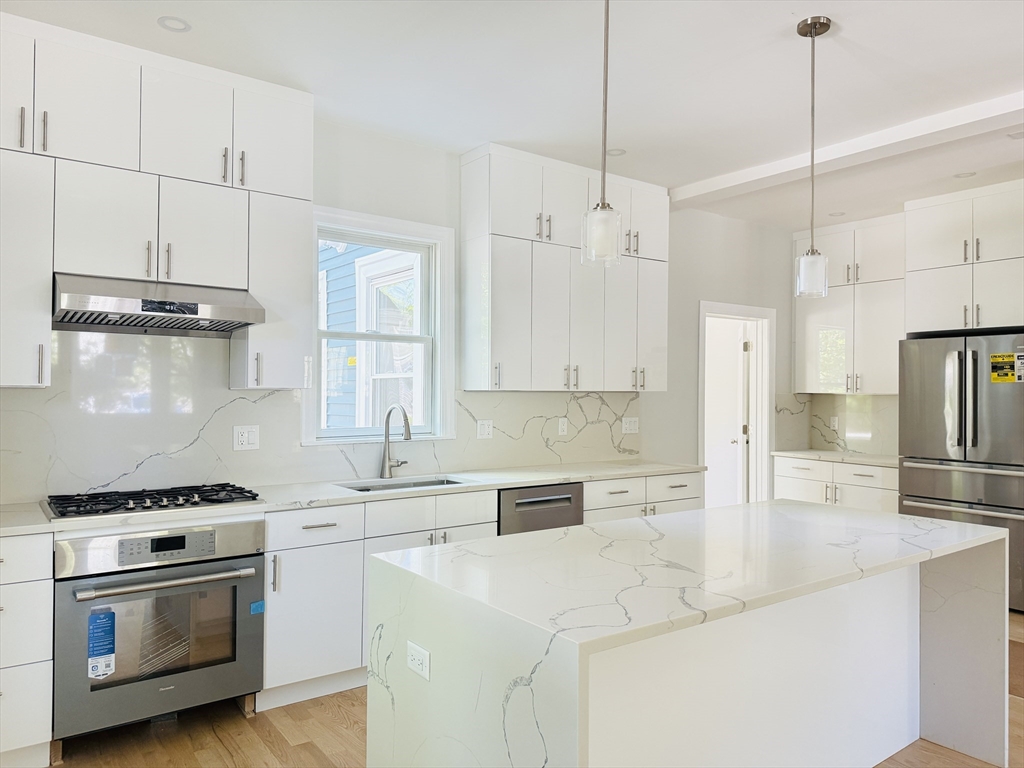 4 Baldwin Street, Unit 4 Newton, MA 02458 - Photo 6 of 30 a kitchen with kitchen island a stove a sink and a refrigerator