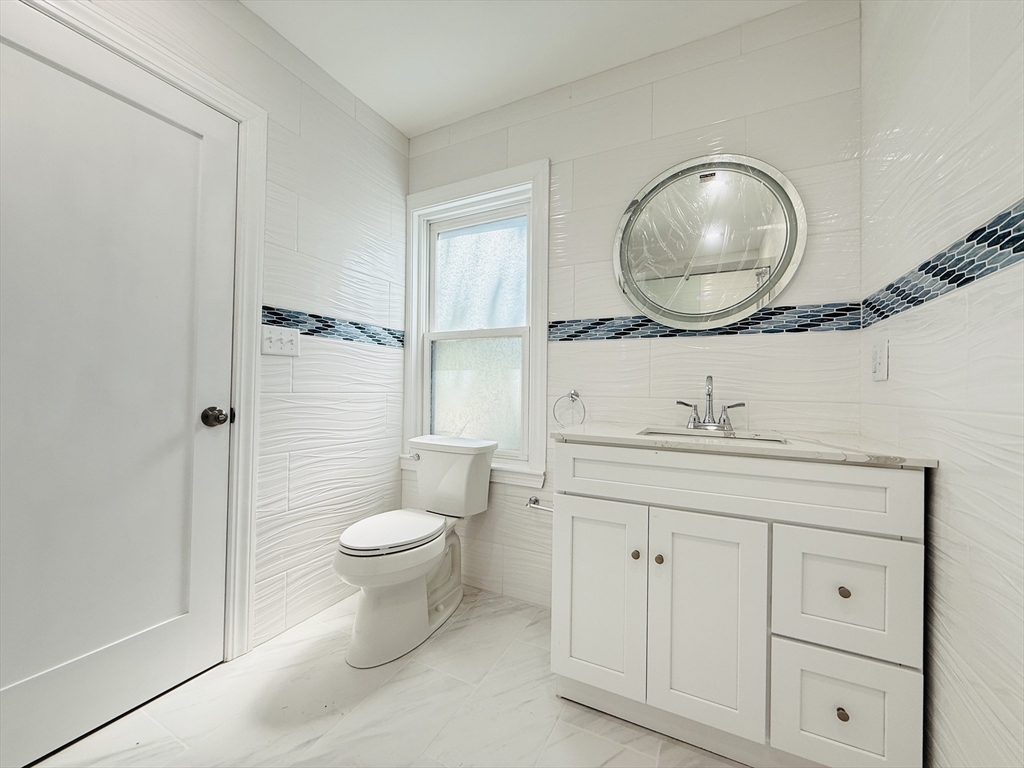 4 Baldwin Street, Unit 4 Newton, MA 02458 - Photo 10 of 30 a bathroom with a toilet sink and mirror