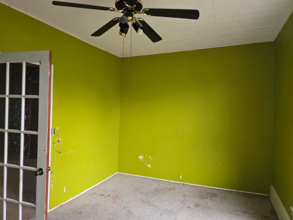 a view of a room with a wall and a ceiling fan