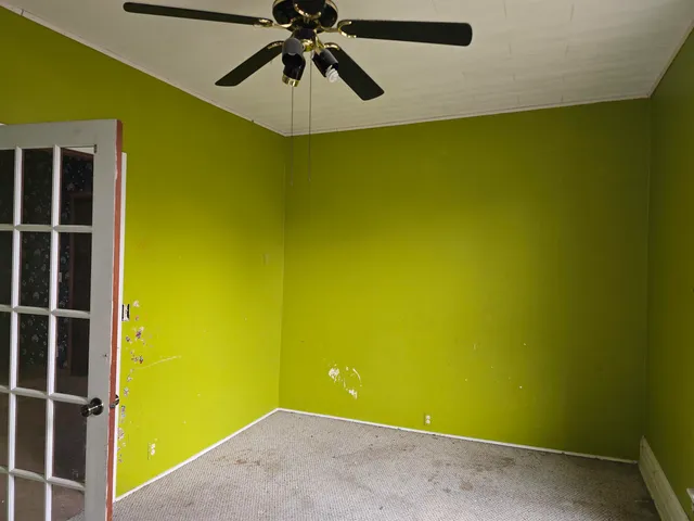 a view of a room with a wall and a ceiling fan