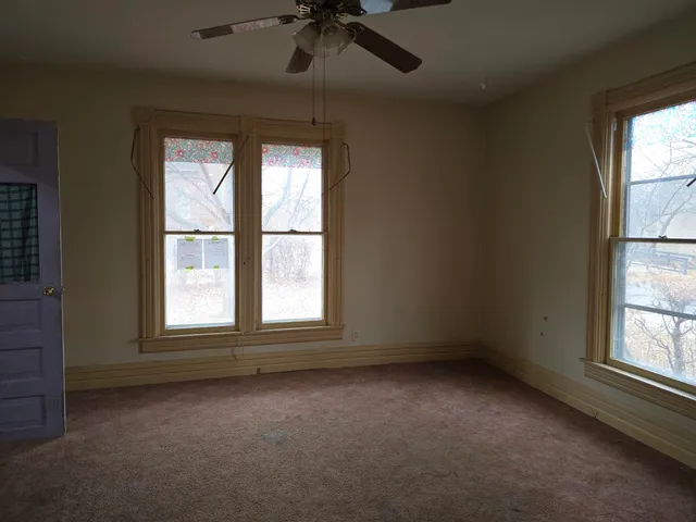 an empty room with windows and closet
