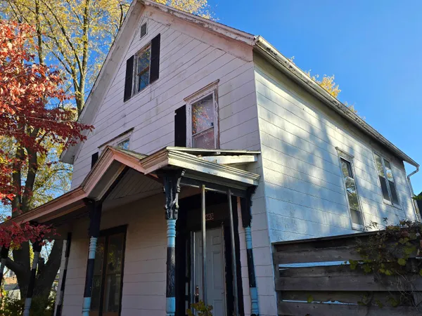a view of a house with a door and wooden wall