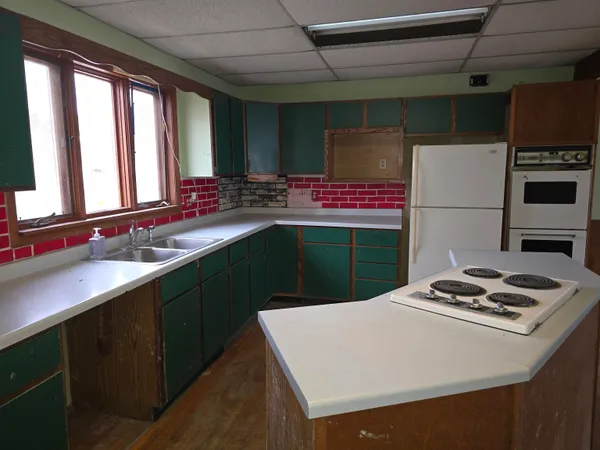 a kitchen with kitchen island a sink stove and refrigerator