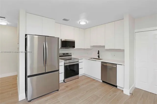 a kitchen with a refrigerator sink and stainless steel appliances