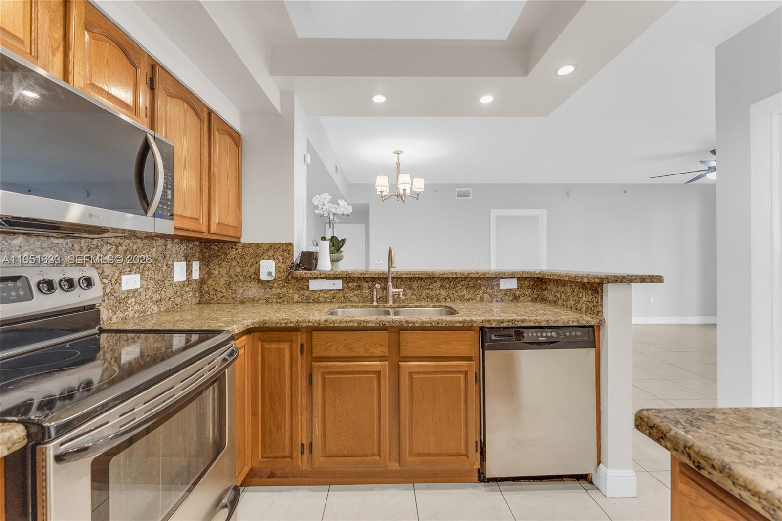 2400 East Preserve Way, Unit 101 Miramar, FL 33025 - Photo 13 of 41 a kitchen with granite countertop a sink stainless steel appliances and cabinets