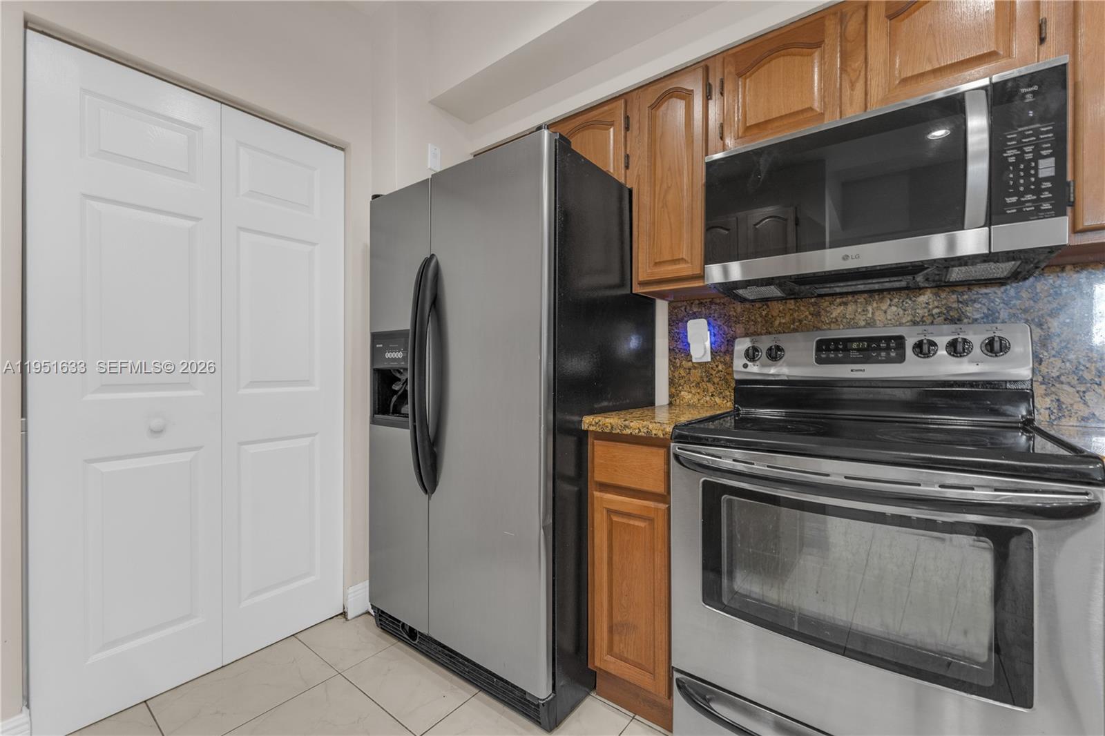 2400 East Preserve Way, Unit 101 Miramar, FL 33025 - Photo 14 of 41 a kitchen with stainless steel appliances granite countertop a stove microwave and refrigerator
