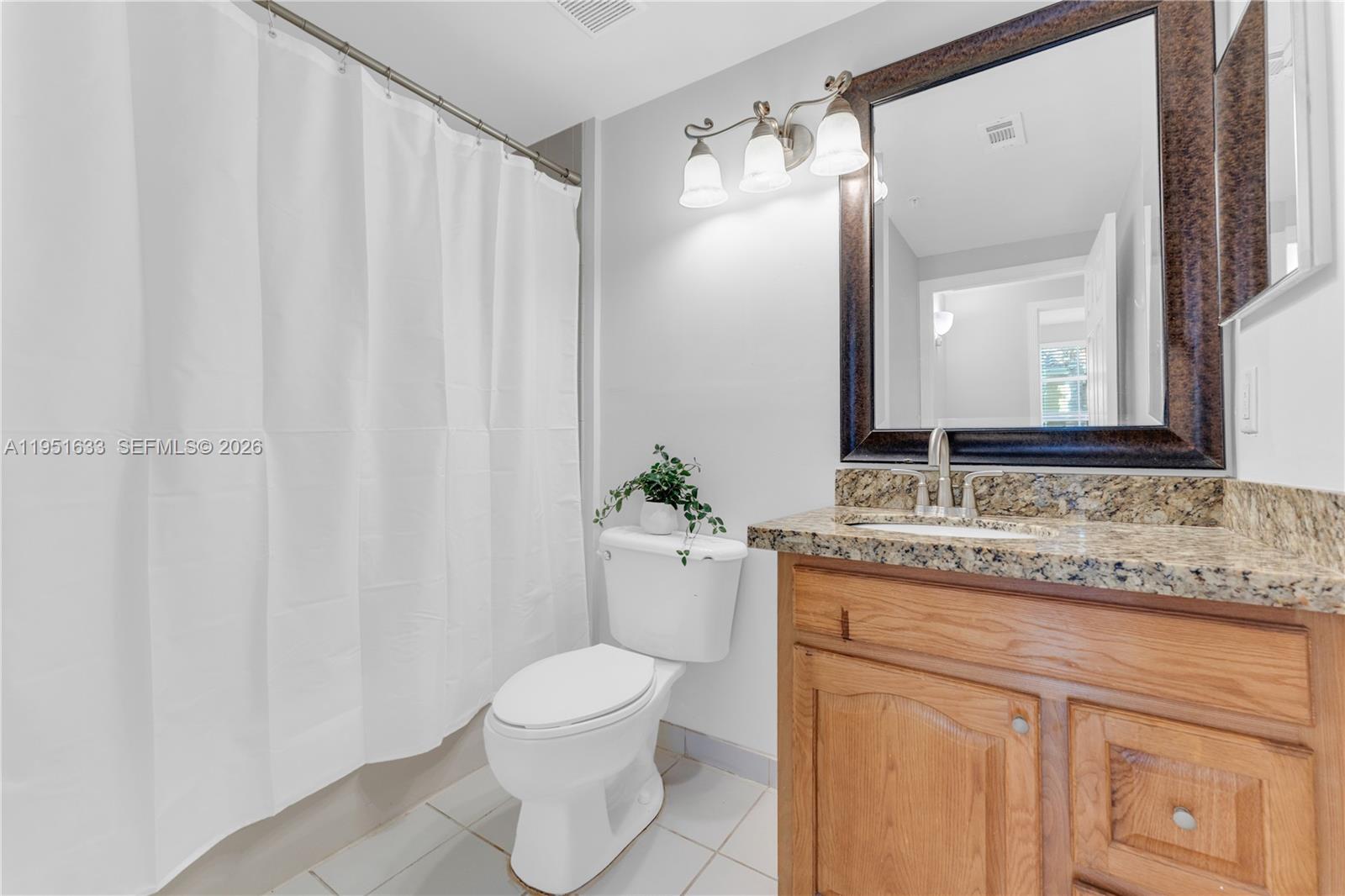 2400 East Preserve Way, Unit 101 Miramar, FL 33025 - Photo 22 of 41 a bathroom with a granite countertop sink and a mirror