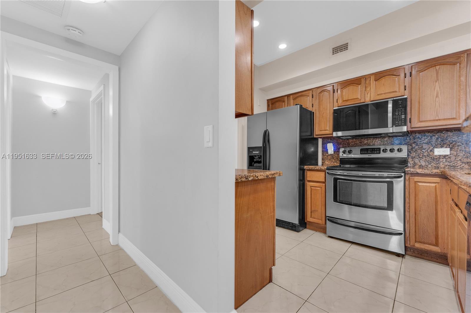 2400 East Preserve Way, Unit 101 Miramar, FL 33025 - Photo 8 of 41 a kitchen with stainless steel appliances granite countertop a stove and a refrigerator