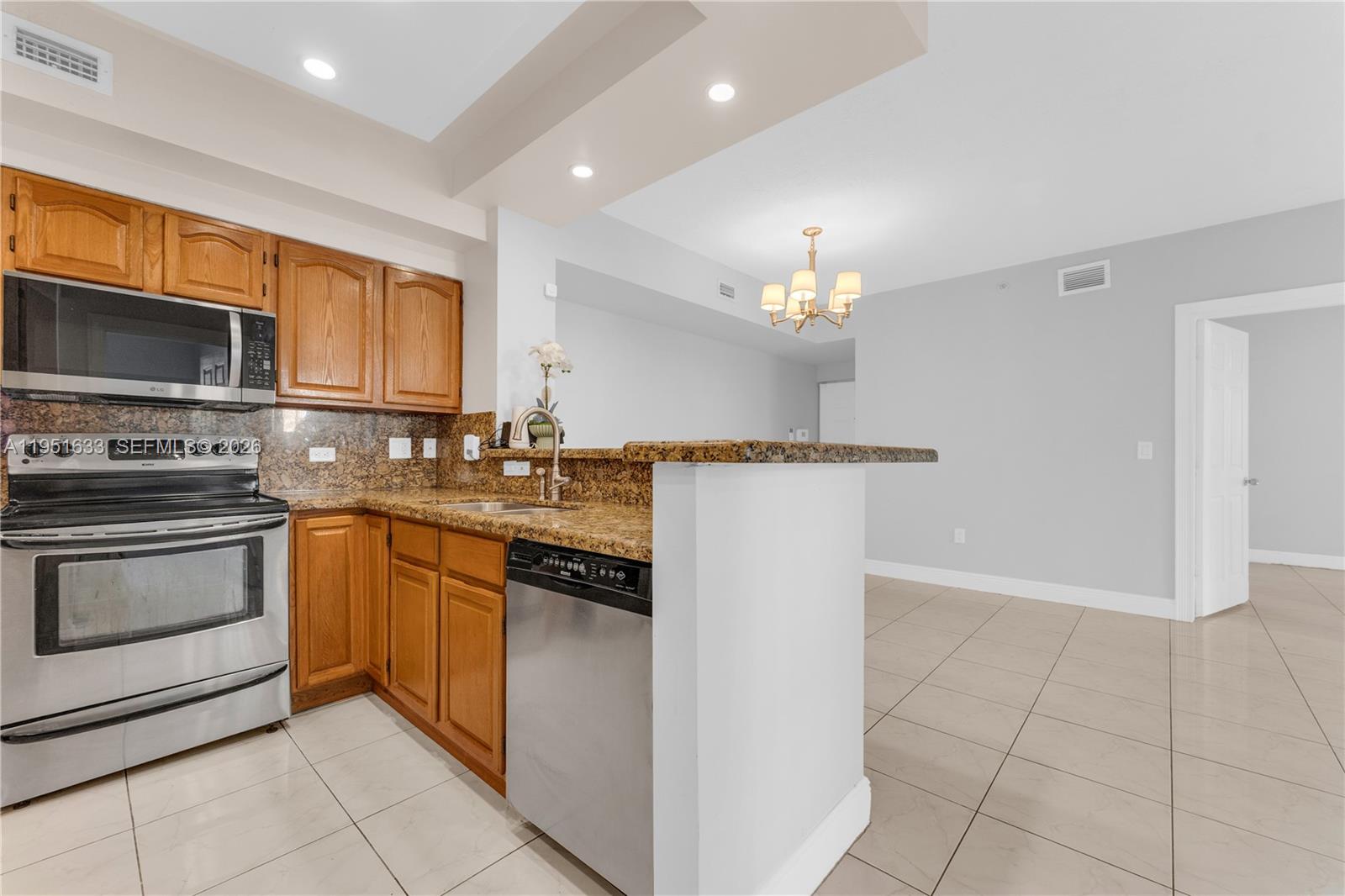 2400 East Preserve Way, Unit 101 Miramar, FL 33025 - Photo 9 of 41 a kitchen with stainless steel appliances granite countertop a stove and a microwave
