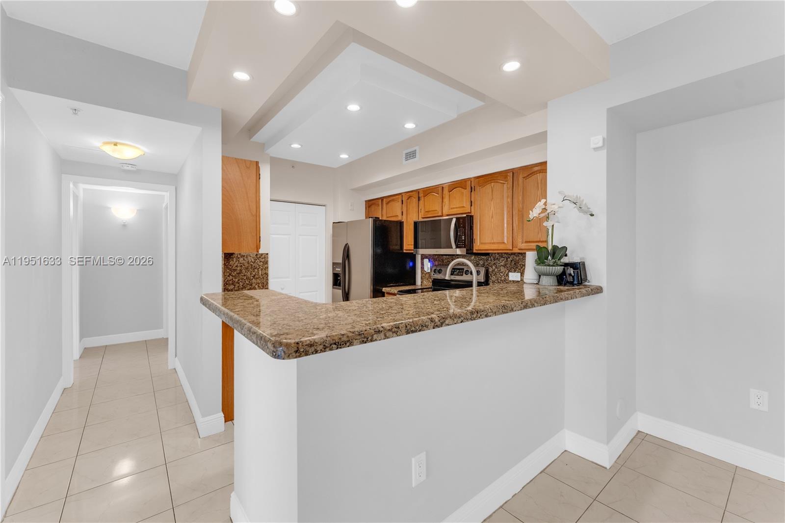 2400 East Preserve Way, Unit 101 Miramar, FL 33025 - Photo 10 of 41 a kitchen with stainless steel appliances granite countertop a sink and a refrigerator