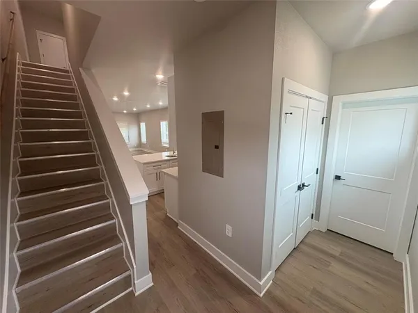 a view of a hallway with wooden floor and entryway