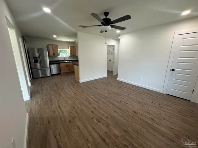 an empty room with wooden floor and entrance