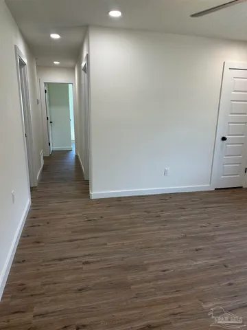 a view of a hallway with wooden floor