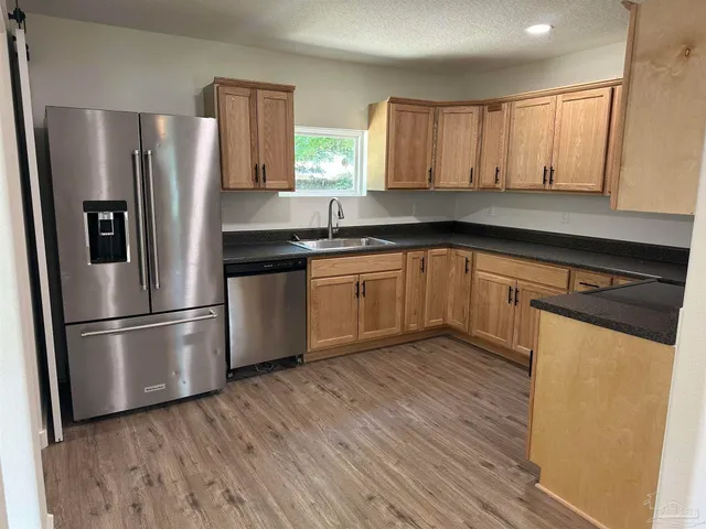 a kitchen with granite countertop a refrigerator and a sink